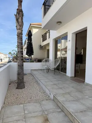 a patio with two chairs and a palm tree at Amour Et Citrons in Protaras