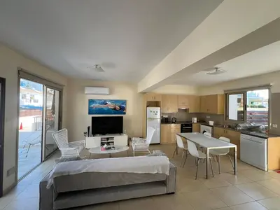 a room with a bed and a table and a kitchen at Amour Et Citrons in Protaras