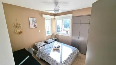 a bedroom with a bed and a couch and a window at 5 Min Walk to Beach, Perfect Seaside Escape 3BR Shared Apartment in Larnaka
