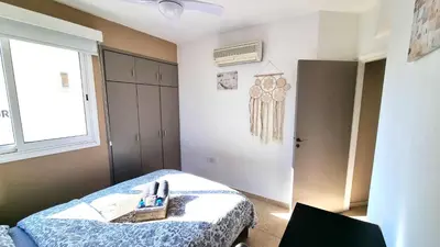 a bedroom with a bed and a window at 5 Min Walk to Beach, Perfect Seaside Escape 3BR Shared Apartment in Larnaka