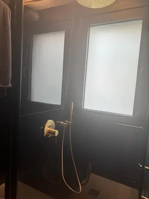 a bathroom with two windows and a hose on the wall at Nicosia Delux in Nicosia