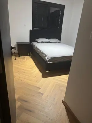 a bedroom with a bed and a wooden floor at Nicosia Delux in Nicosia