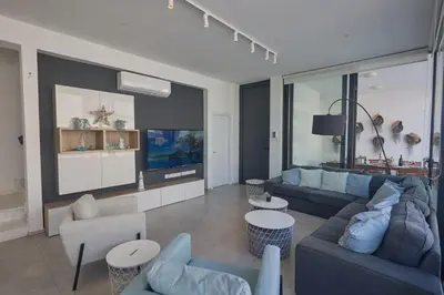 a living room with a blue couch and a tv at Protaras Almaria Villa ALM03 in Protaras