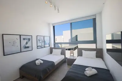 a bedroom with two beds and a large window at Protaras Almaria Villa ALM03 in Protaras