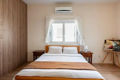a bedroom with a large bed and a window at Central, renovated, fully equipped, spacious 3BD in Strovolos