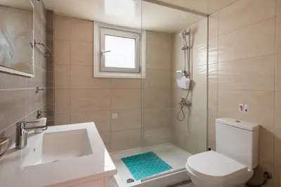 a bathroom with a toilet and a sink and a shower at Central, renovated, fully equipped, spacious 3BD in Strovolos