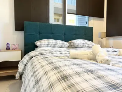 a bedroom with a bed with a green headboard at Albert's Apartment Center 101K in Larnaka