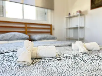 a room with four beds with folded towels on them at Albert's Apartment Center 101K in Larnaka