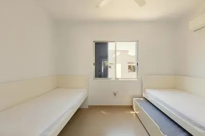 two beds in a room with a window at Family Fig Tree Bay House in Protaras