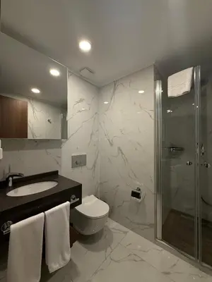 a bathroom with a shower and a toilet and a sink at Grand sapphire resort Ötüken yeni iskele North Cyprus in İskele