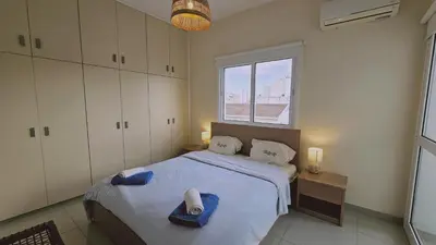 a bedroom with a large bed with a window at STAY Amphora Apartment in Larnaka