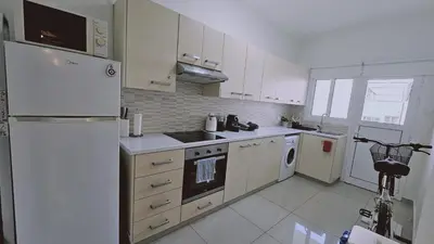 a white kitchen with a refrigerator and a dishwasher at STAY Amphora Apartment in Larnaka