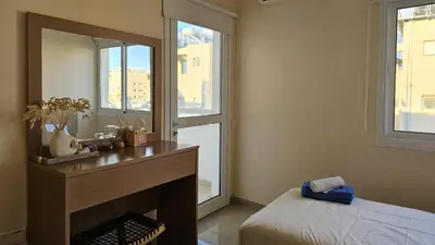 a bedroom with a fireplace and a mirror at STAY Amphora Apartment in Larnaka