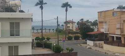 an empty city street with palm trees and a building at Magic Maisonette 250m from the beach in Larnaka
