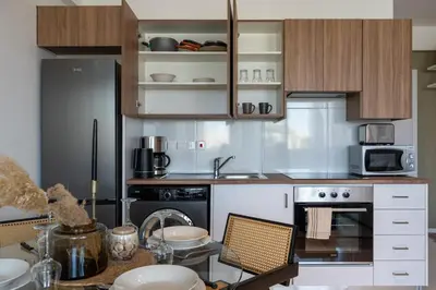 a kitchen with a refrigerator and a table with chairs at Luna - Homely Studio W Balcony in Larnaca in Larnaka