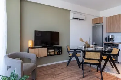 a living room with a table and chairs and a tv at Luna - Homely Studio W Balcony in Larnaca in Larnaka