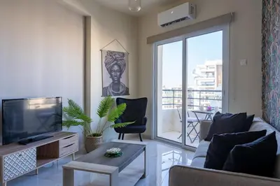 a living room with a couch and a tv at Mosaic - 1 Bedroom Apartment in Larnaca in Larnaka