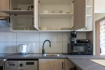 a kitchen with a sink and a microwave at Mosaic - 1 Bedroom Apartment in Larnaca in Larnaka