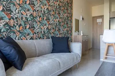 a couch in a living room with a floral wallpaper at Mosaic - 1 Bedroom Apartment in Larnaca in Larnaka
