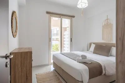 a bedroom with a large bed and a window at Infinity - One-Bedroom Apt W Terrace in Larnaca in Larnaka