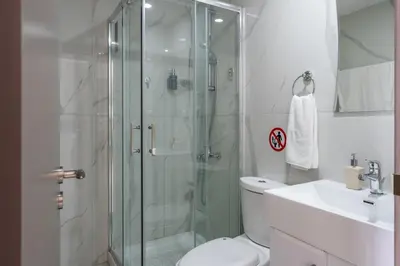 a bathroom with a shower and a toilet and a sink at Infinity - One-Bedroom Apt W Terrace in Larnaca in Larnaka