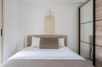 a bedroom with a large bed with white sheets at Infinity - One-Bedroom Apt W Terrace in Larnaca in Larnaka