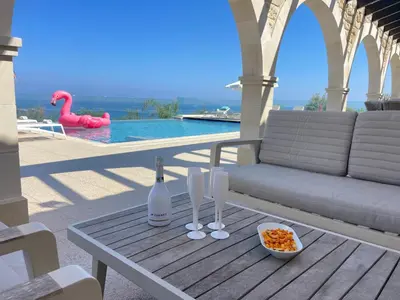 a table with two wine glasses and a bowl of food at Sunrise Dream Villa-Protaras in Protaras
