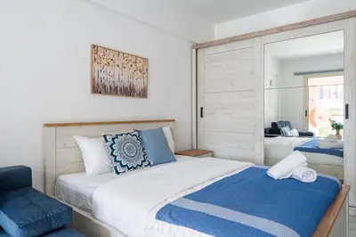 a bedroom with a large bed and a mirror at Sunny Side Studio W Terrace in Larnaca in Larnaka