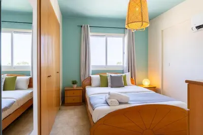 a bedroom with two beds and two windows at Bayview 2-BR Apartment W Terrace in Larnaca in Larnaka