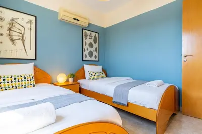 two beds in a room with blue walls at Bayview 2-BR Apartment W Terrace in Larnaca in Larnaka