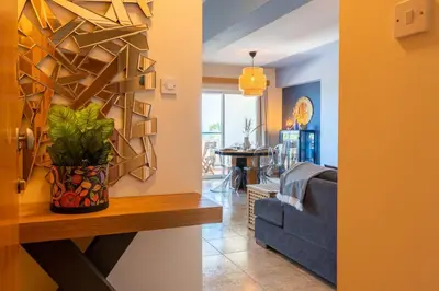 a living room with a blue couch and a table at Bayview 2-BR Apartment W Terrace in Larnaca in Larnaka