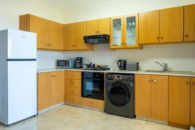 a kitchen with a refrigerator and a washing machine at Bayview 2-BR Apartment W Terrace in Larnaca in Larnaka