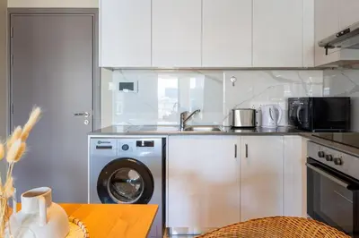 a kitchen with a washing machine and a sink at Sundrop - 1-Bedroom Apt W Terrace in Larnaca in Larnaka