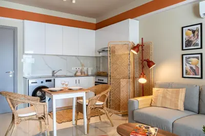 a kitchen and a living room with a table and a couch at Sundrop - 1-Bedroom Apt W Terrace in Larnaca in Larnaka