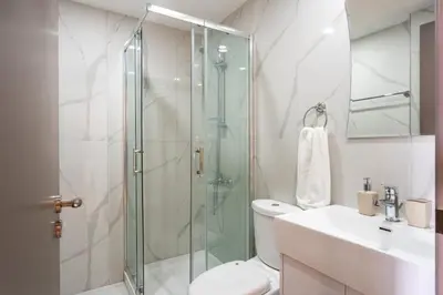 a bathroom with a shower and a toilet and a sink at Sundrop - 1-Bedroom Apt W Terrace in Larnaca in Larnaka