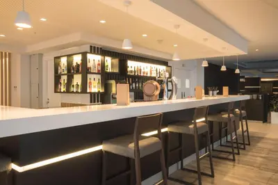 a bar in a restaurant with bar stools at Evalena Beach Hotel in Protaras
