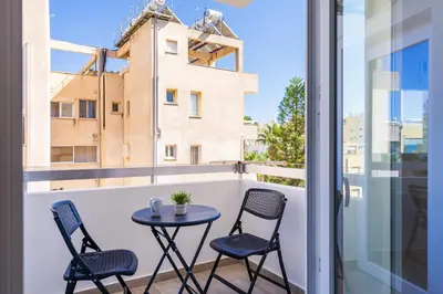 a patio with two chairs and a table on a balcony at Vibe - 1 Bedroom Apartment W Balcony in Larnaca in Larnaka