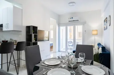 a dining room and kitchen with a table and chairs at Vibe - 1 Bedroom Apartment W Balcony in Larnaca in Larnaka