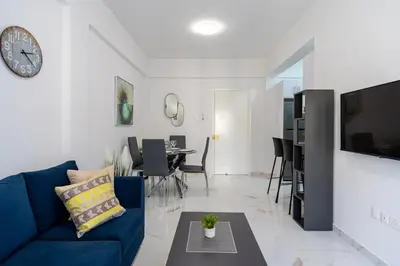a living room with a blue couch and a table at Vibe - 1 Bedroom Apartment W Balcony in Larnaca in Larnaka