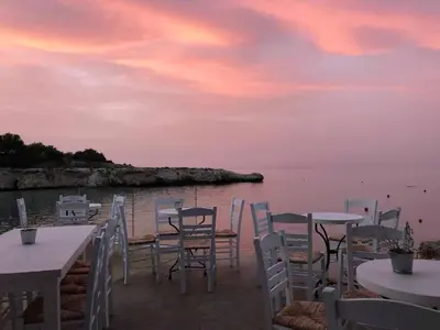 a group of tables and chairs with a view of the water at Apartment Sun 'n Joy in Paralimni