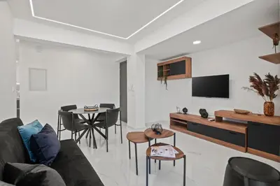 a living room with a couch and a tv at Maestro City Apartments in Larnaka