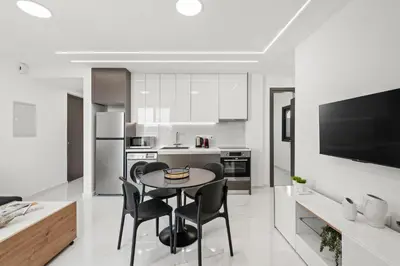 a kitchen with a table and chairs in a room at Maestro City Apartments in Larnaka