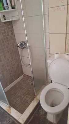 a bathroom with a shower and a toilet at Room with entrance from yard near to Larnaca in Livadhia