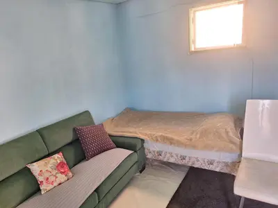 a small room with a couch and a bed at Room with entrance from yard near to Larnaca in Livadhia