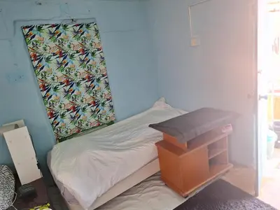 a small bedroom with a small bed and a table at Room with entrance from yard near to Larnaca in Livadhia