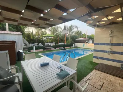a patio with a table and a swimming pool at Sunshine Villa Private Pool Luxury Garden 2' walk to Kalamies beach Pernera in Protaras