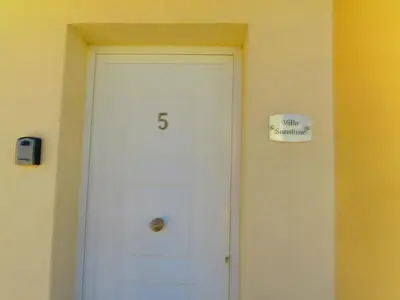 a door in a room with a sign on the wall at Sunshine Villa Private Pool Luxury Garden 2' walk to Kalamies beach Pernera in Protaras