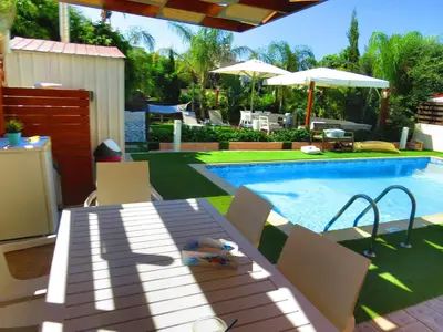 a swimming pool with a table and chairs next to it at Sunshine Villa Private Pool Luxury Garden 2' walk to Kalamies beach Pernera in Protaras