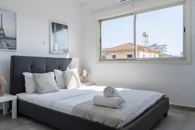 a bedroom with a large bed with a large window at Liric - 3 Bedroom Apt W Balcony in Larnaca in Larnaka