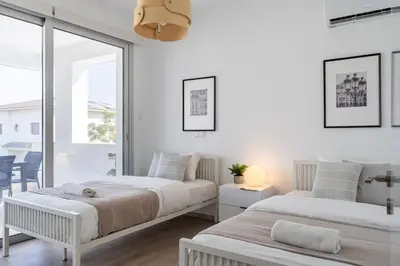 two beds in a bedroom with white walls at Valleria - 2 BR Apartment W Pool in Larnaca in Larnaka
